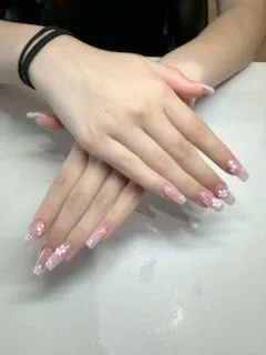 Nail technician applying red polish to child's nails at Perfect Nails