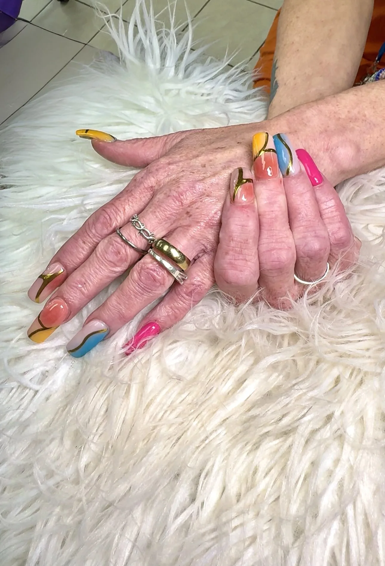 Purple and pink floral nail art with gold accents at Perfect Nails